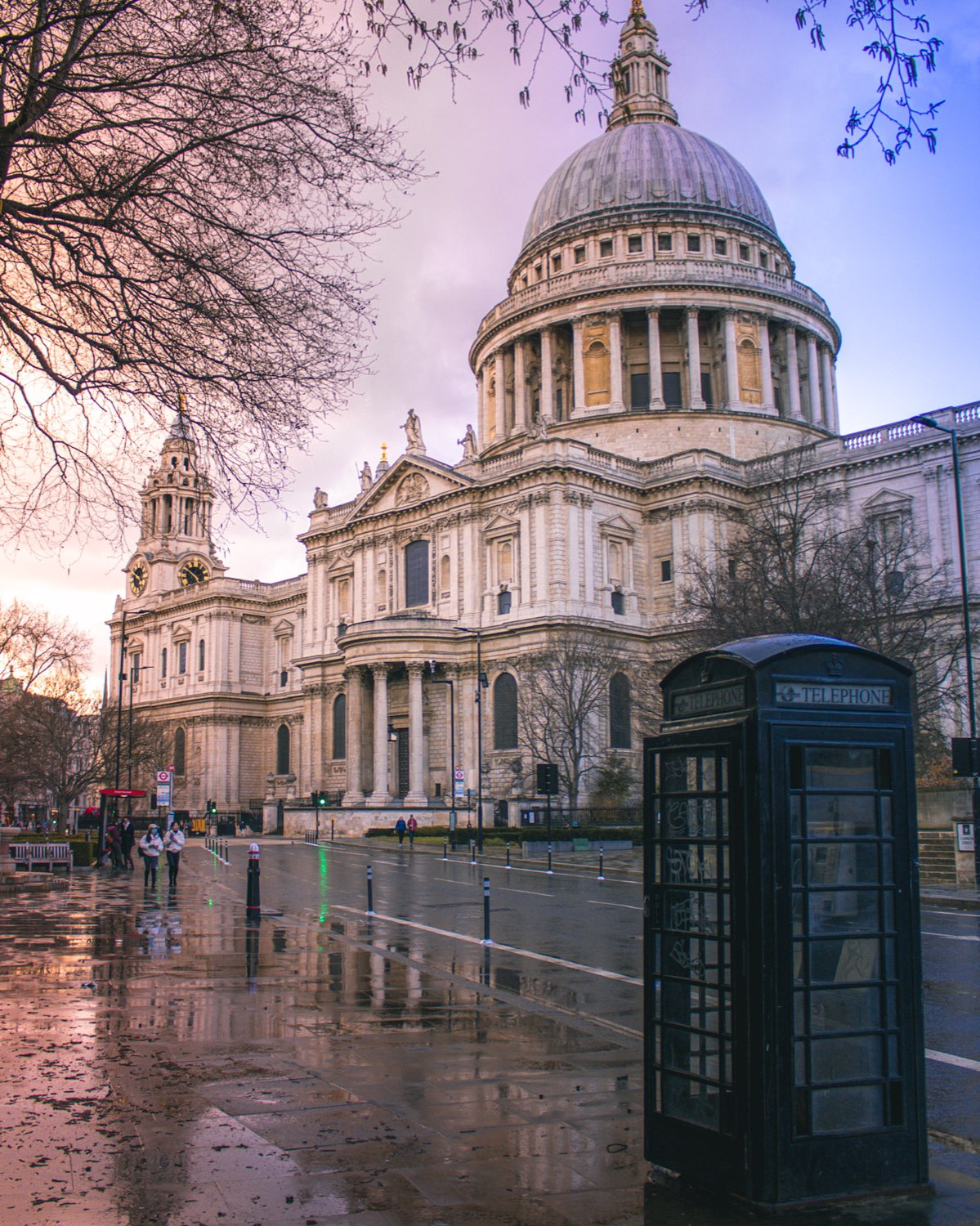St Paul's Cathedral at dusk with the dome reflected in a wet road and a dark police box in the foreground